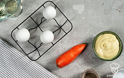 Морковь ополосните, почистите и натрите на мелкой терке. Яйца положите в кастрюлю с холодной водой, вскипятите и готовьте 8-9 минут. Затем остудите в холодной воде, очистите от скорлупы и разрежьте пополам. Извлеките желтки и разомните их вилкой. Петрушку вымойте и отделите листочки от стебля.