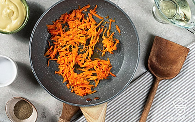 Приготовьте зажарку. Разогрейте сковороду и влейте небольшое количество растительного масла. Выложите морковь, обжаривайте на среднем огне приблизительно 4 минуты. Остудите зажарку в течение нескольких минут.