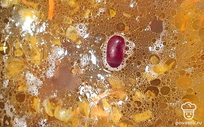 В кастрюлю добавьте зажарку и фасоль. Варите 5 минут.