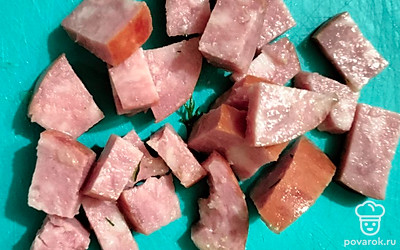 Нарежьте небольшими кубиками колбасу. 