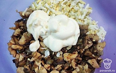 Отварные куриные яйца натрите на терке и соедините их с мясом и грибами в отдельной посуде. Прибавьте майонез и перемешайте.