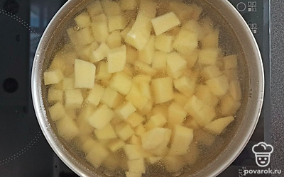 Нарежьте картофель на небольшие кубики. Добавьте картошку в кастрюлю, варите 10 минут.