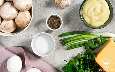 Яйца помойте, залейте водой, доведите до кипения и варите 8-10 минут с момента закипания. Остудите в холодной воде, очистите от скорлупы и мелко нарежьте или натрите на крупной терке. Грибы ополосните и обсушите, отделите ножки от шляпок. Ножки мелко нарежьте. Сыр натрите на терке с мелкими зубьями. Зелень и листья салата ополосните, стряхните лишнюю жидкость. Зелень измельчите ножом, оставив одну веточку петрушки для украшения. Разогрейте духовку до 200 градусов.