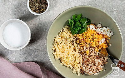 Приготовьте начинку. В миске смешайте нарезанные ножки грибов, тертый сыр, яйца. Всыпьте зеленый лук и петрушку. Посолите по вкусу, приправьте молотым орегано и тщательно перемешайте, заправив майонезом.