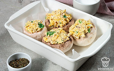 Нафаршируйте грибы и поставьте запекаться. Яичной начинкой наполните шляпки шампиньонов. Подготовьте противень, застелите его бумагой для выпечки. Разложите на нем закуску и поставьте в духовку на 15-20 минут при температуре 180-200 градусов.