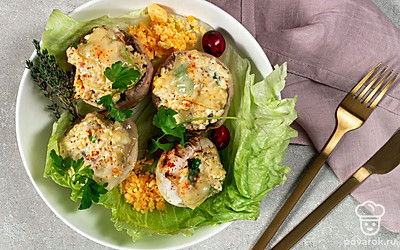 Выложите на сервировочное блюдо листья салата, на них перенесите закуску и украсьте шляпки грибов листочками свежей зелени. Фаршированные шампиньоны с яйцом подавайте горячими.