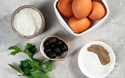 Отварите яйца вкрутую в течение 8 минут после закипания. Остудите и очистите их. Разрежьте вдоль и достаньте желтки. Промойте и просушите зелень, половину мелко порубите, у половины отделите целые листочки. Маслины мелко нарежьте, оставив 10 половинок для украшения.