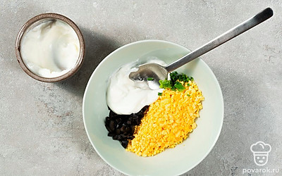 Приготовьте начинку. Разомните желтки, добавьте к ним нарезанные маслины, рубленую зелень и йогуртовую заправку. Посолите, поперчите и перемешайте.