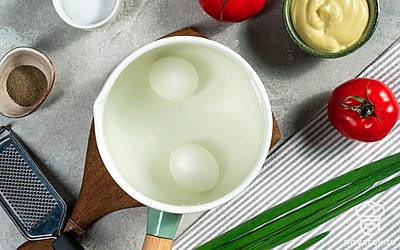 Приготовьте яйца для закуски. В кастрюлю с холодной водой опустите яйца. Поставьте на сильный огонь и вскипятите воду. Варите яйца 10 минут после закипания, затем остудите в холодной воде и очистите. Затем натрите их на терке с мелкими ячейками.