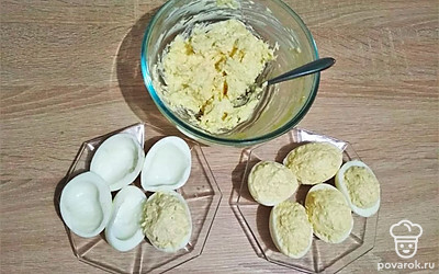 Смешайте сыр, желтки, чеснок и майонез. Нафаршируйте полученной массой половинки яиц и выложите на красивое блюдо. Если останется лишняя сырная масса – скатайте ее в небольшие шарики, и тоже уложите на блюдо.