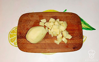 Картофель очистите. Нарежьте кубиками и выложите его в кастрюлю к перловке. 