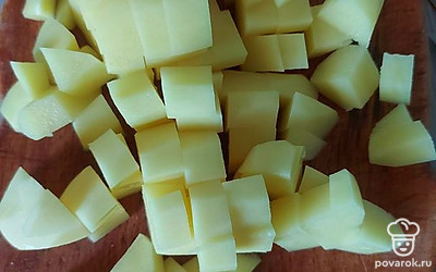 Картошку почистите и нарежьте небольшими кубиками. Тоже добавьте в кастрюлю.