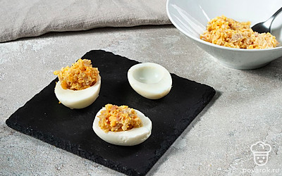 Приготовьте фаршированные яйца. Смешайте майонез, горчицу, скумбрию и добавьте желток. Наполните яйца этой начинкой.