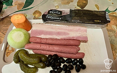 Не забудьте снимать пенку с картошки. Морковь натрите на крупной терке, лук и огурцы нарежьте на мелкие кубики. Маслины разрежьте пополам. Рассол из-под маслин и огурцов перелейте в отдельный стакан. Этот «бульон» еще пригодится. Охотничьи колбаски нарежьте колечками, а грудинку покрошите на удобные кубики. 