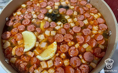 К уже сваренной картошке отправьте всю зажарку. Аккуратно переложите и перемешайте, не забывая снимать образовывающуюся жирную пленку. Туда же перелейте рассол из-под маслин и огурцов. Благодаря ему соль не понадобится. 