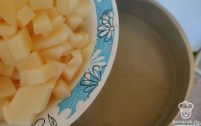 Как только курица сварилась, достаньте ее и остудите. В это время нарежьте картофель, отправьте в бульон.