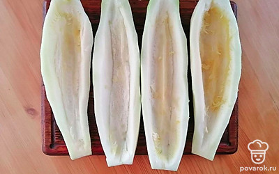 Кабачки очистите от кожуры, разрежьте вдоль пополам. Выньте из середины половинки кабачка семена и немного мякоти. Удобнее это сделать ложкой. Должны получиться 4 лодочки из кабачков.