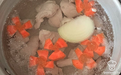 Добавить в бульон морковку и очищенный лук. Отварить до готовности морковки. Лук из бульона убрать.