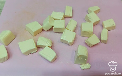 Плавленый сыр нарезаем кубиками и добавляем в кастрюлю. 