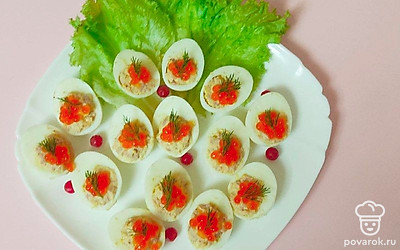 Фаршированные яйца подайте на блюде с листьями салата. Украсьте половинки зеленью укропа. На каждую положите чайную ложечку икры.