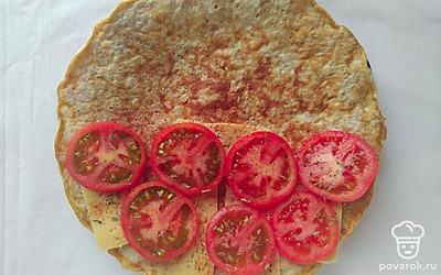 Распределите тесто по сковороде. Выпекайте блин по 1 минуте с каждой стороны. Выложите на одну сторону овсянаблина сыр и помидоры, посыпьте базиликом и паприкой и накройте второй стороной.