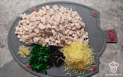 Мелко нарежьте куриное филе.Чеснок пропустите через пресс, нарежьте зелень.Сыр натрите на мелкой терке .Маслины порежьте пополам.Орехи измельчите в крошку .