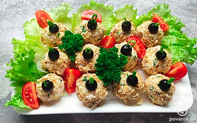 Украсьте шарики маслинами, из зеленого лука сделайте небольшие петли. Посыпьте гранатовыми зернами и подавайте на листьях салата.