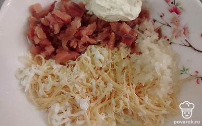 Отварите яйца. Очистите от скорлупы. Натрите на мелкой терке. Отправьте яйца в глубокую миску.