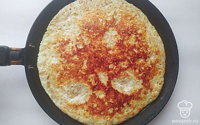 Вылейте смесь на сковороду и распределите по всей поверхности с помощью ложки. Обжарьте блин с обеих сторон по 3 минуты на слабом огне до золотистой корочки.