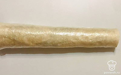 Очень аккуратно сверните лаваш с семгой очень плотным рулетом. Заверните рулет из лаваша и начинки в пищевую пленку и положите в холодное место на 1-2 часа для охлаждения и для его полной пропитки.