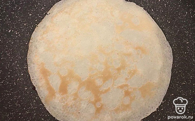 На разогретую сковороду налейте в центр половину половника жидкости и обжаривайте до готовности по 1 минуте с каждой стороны. По завершению процесса жарки, остывшие блины смажьте шоколадной пастой и заверните их.