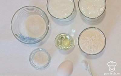 Муку насыпьте в миску, а ряженку налейте в стакан. Яйцо положите на стол. Растительное масло налейте в стакан. Сахар, соду и соль насыпьте в емкости.