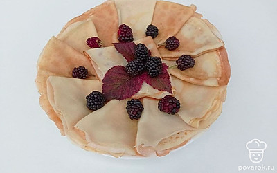 Блины сложите в треугольники и поставьте на тарелку. Сверху можно украсить ежевикой или малиной.