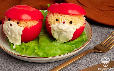 Накройте помидоры ранее отрезанными верхушками. Горошком перца сделайте глазки и носик Деду Морозу, а майонезом бороду. Приятного аппетита!