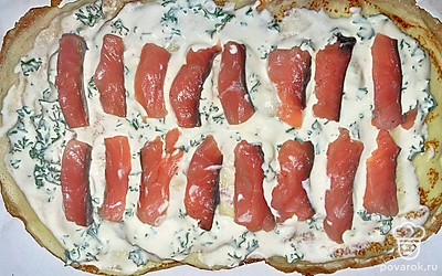 Выложите блины внахлест. Размажьте творожную начинку на блины тонким слоем. Семгу порежьте на небольшие кусочки и выложите на начинку.