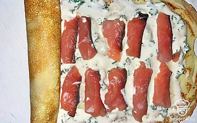 Сверните блины в плотный рулет. Обрежьте пустые края. Выложите сверху на рулет красную икру.