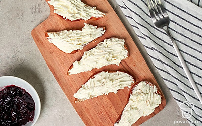 Соберите тост. В маленькой мисочке смешайте сыр, сахар и ванилин. На подсушенный хлеб намажьте сырную смесь, а затем черничный джем.