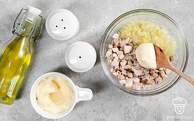 Приготовьте начинку. Репчатый лук нарежьте мелкими кубиками, а чеснок измельчите. Сковороду поместите на огонь, влейте в нее немного растительного масла и выложите нарезанные ингредиенты. Обжарьте их в течение 5 минут, постоянно помешивая, после чего снимите с огня. Грудку нарежьте небольшими кусочками и выложите в глубокую миску. Добавьте зажарку, майонез и специи, перемешайте.