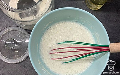 В миску влейте молоко, добавьте сахар, соль и, постепенно помешивая венчиком, введите муку. Далее добавьте растительное масло и все хорошо перемешайте.