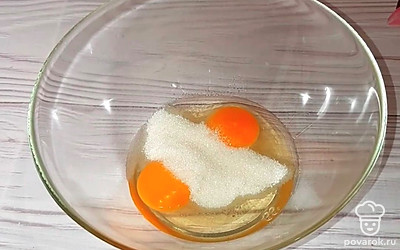 В миске смешать 2 яйца и сахар. Добавить щепотку соли и хорошо перемешать венчиком.