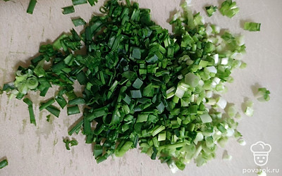 Помойте зелёный лук, мелко нарежьте и переложите в глубокую тарелку.