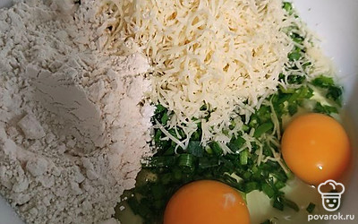 Натрите на мелкой тёрке сыр Российский и добавьте его к зелёному луку.