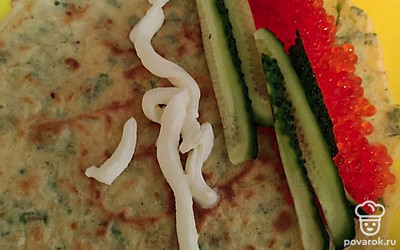 На блин положите красную икру, огурец и творожный сыр. Заверните в трубочку.