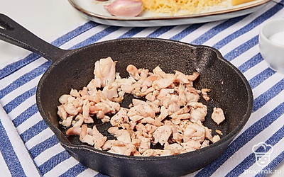 Начните приготовление начинки. Сковороду поместите на средний огонь, добавьте немного растительного масла и оставьте разогреваться. Пока масло греется, нарежьте куриное филе небольшими кусочками или кубиками. Затем выложите мясо на сковороду, посолите, поперчите и обжарьте в течение нескольких минут, периодически помешивая. После этого снизьте огонь на минимум и оставьте филе готовиться.