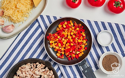 Приготовьте начинку. Болгарский перец очистите от плодоножки и семян, нарежьте мелкими кубиками. Аналогично нарежьте репчатый лук. Добавьте нарезанные овощи к куриному филе, перемешайте и оставьте готовиться. Затем измельчите чеснок и добавьте к остальным ингредиентам. Обжарьте начинку еще 3-4 минуты, тщательно перемешивая. В конце добавьте в сковороду кукурузу, перемешайте, подержите на минимальном огне еще несколько минут, после чего снимите с плиты.