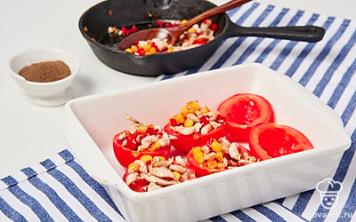 Приготовьте закуску. Наполните помидоры готовой начинкой из овощей и курицы до самого верха. Посыпьте тертым сыром. Переложите фаршированные помидоры в форму и поместите в духовку. Запекайте закуску в течение 10 минут при температуре 190 градусов. Затем снизьте температуру до 170 градусов и оставьте помидоры готовиться еще на 15 минут.