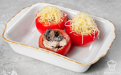 Приготовьте закуску. Духовку включите разогреваться до 180 градусов. Подготовленные заранее помидоры наполните начинкой из грибов и мяса. Сыр натрите на терке, посыпьте им закуску. Переложите фаршированные помидоры в форму для запекания, накройте их срезанными верхушками и отправьте в духовку на 30 минут.