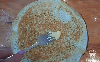 Выкладываем готовый блин на тарелку и смазываем с одной стороны сливочным маслом. 