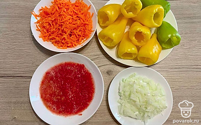Нарежьте мелким кубиком лук, а морковь натрите на крупной терке. Помидоры натрите на терке. Перец отчистите от семян и достаньте середину.