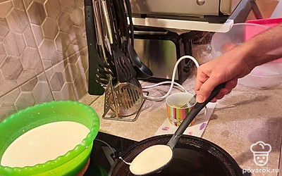 Вылить тесто на сковороду, равномерно распределив его по поверхности.